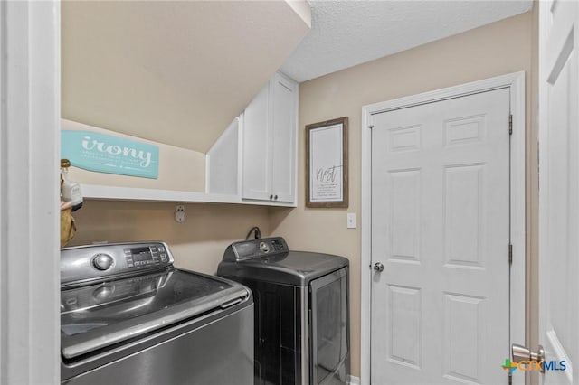 503 Ashland Crk, Victoria, TX 77901 - washroom featuring washer and dryer, cabinet space, and a textured ceiling