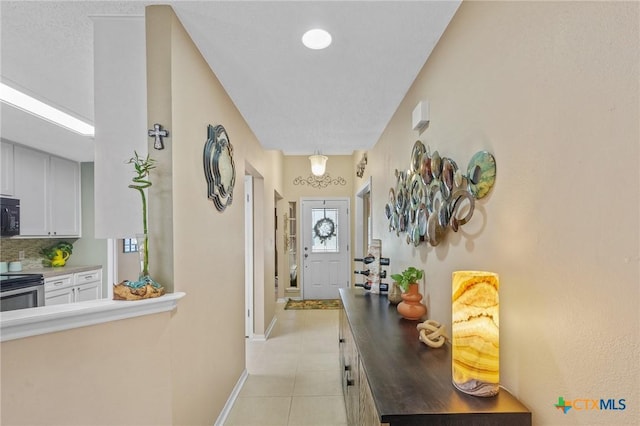 503 Ashland Crk, Victoria, TX 77901 - hallway with light tile patterned floors and baseboards