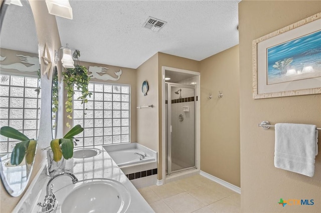 503 Ashland Crk, Victoria, TX 77901 - bathroom with a stall shower, a bath, tile patterned flooring, a textured ceiling, and double vanity