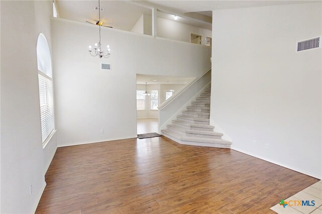 7016 Brandon Dr, Temple, TX 76502 - unfurnished living room with a chandelier, wood finished floors, stairway, and a high ceiling