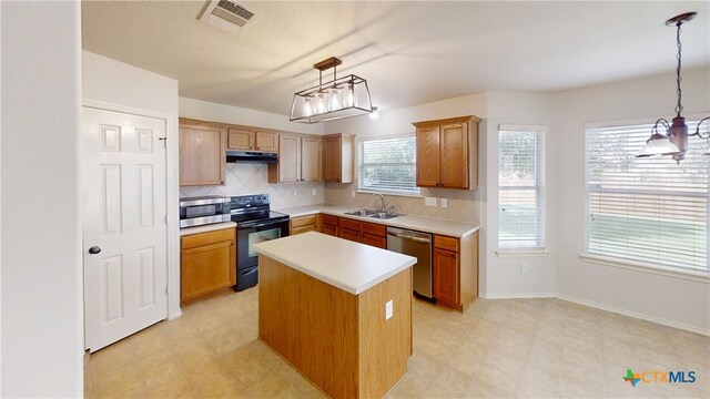 7016 Brandon Dr, Temple, TX 76502 - kitchen featuring stainless steel appliances, under cabinet range hood, backsplash, light countertops, and a kitchen island