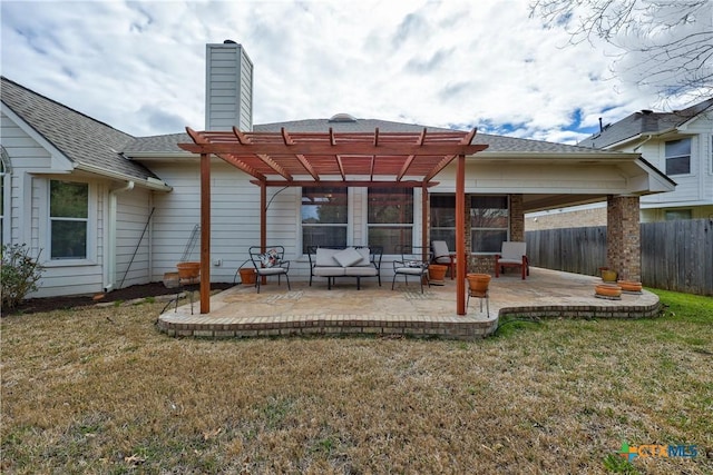 back of property with a lawn, a pergola, fence, a chimney, and a patio area