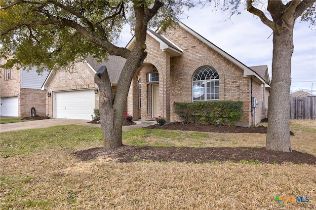 view of front facade featuring a front lawn, fence, concrete driveway, an attached garage, and brick siding