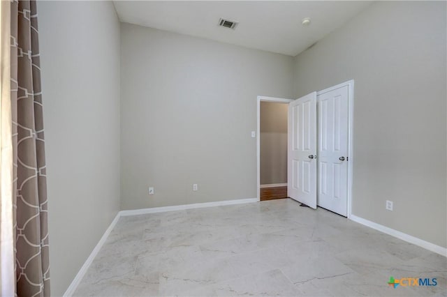 spare room featuring visible vents, marble finish floor, and baseboards