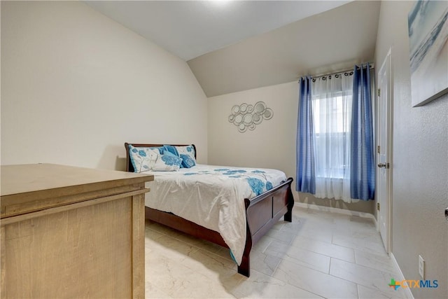 bedroom with baseboards and lofted ceiling