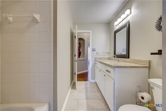 bathroom featuring toilet, vanity, and baseboards