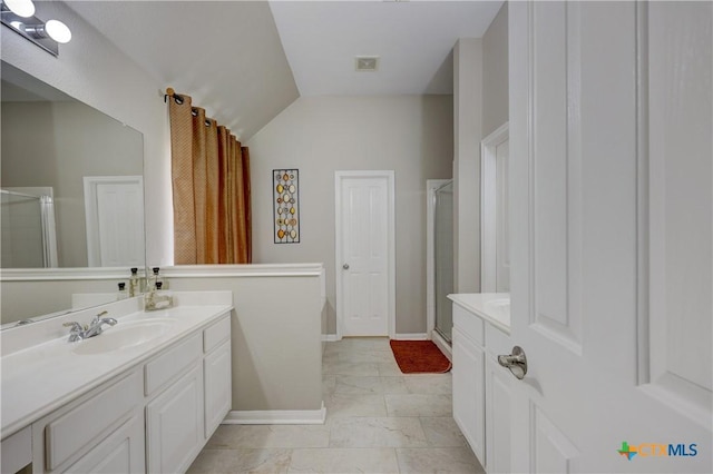 full bath featuring vanity, a shower stall, baseboards, and vaulted ceiling