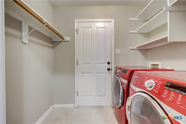 washroom with baseboards, laundry area, and washing machine and clothes dryer