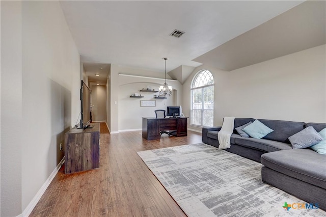 living room featuring a notable chandelier, visible vents, baseboards, and wood finished floors