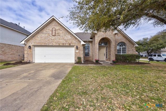 view of front facade with a front lawn, a garage, brick siding, and driveway