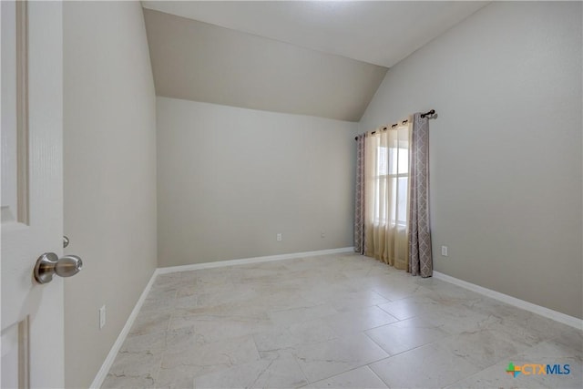 unfurnished room featuring vaulted ceiling, baseboards, and marble finish floor