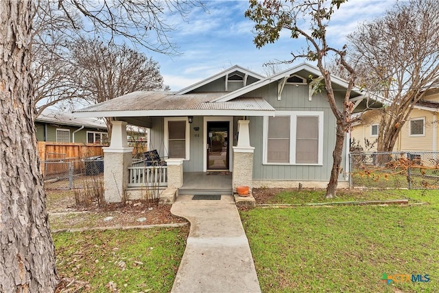 bungalow with covered porch and a front yard