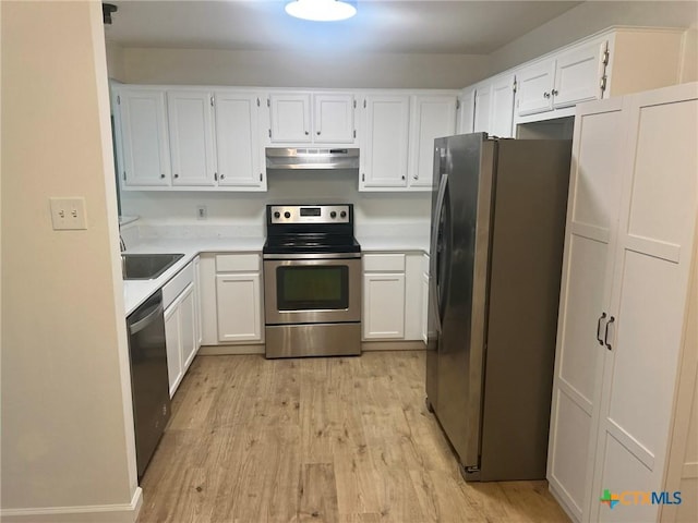 836 Mica Ln, Leander, TX 78641 - kitchen with appliances with stainless steel finishes, under cabinet range hood, light wood finished floors, and white cabinetry