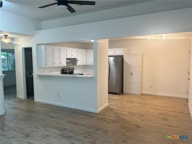 836 Mica Ln, Leander, TX 78641 - kitchen featuring stainless steel appliances, under cabinet range hood, a ceiling fan, white cabinetry, and light wood-style flooring