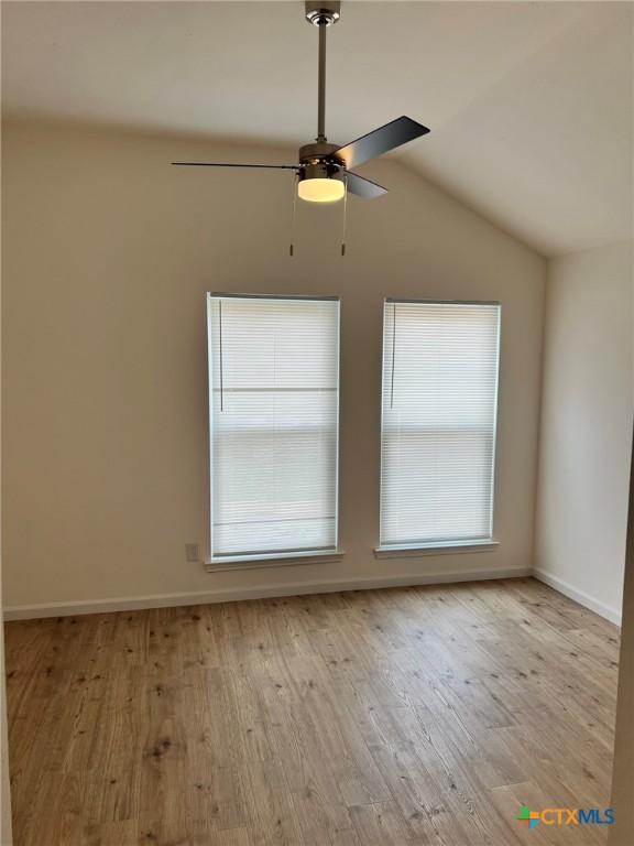 836 Mica Ln, Leander, TX 78641 - spare room with a ceiling fan, wood finished floors, lofted ceiling, and baseboards