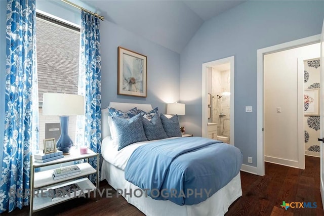 bedroom with vaulted ceiling, wood finished floors, baseboards, and ensuite bathroom