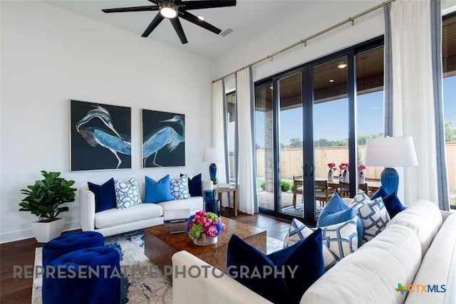 living area featuring a ceiling fan, wood finished floors, and baseboards