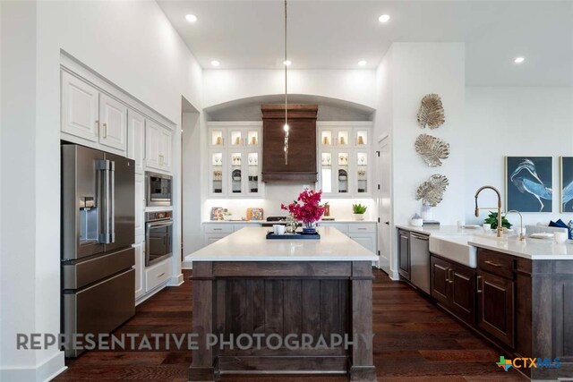 kitchen featuring a sink, stainless steel appliances, dark wood finished floors, and white cabinets