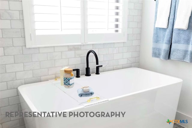 bathroom featuring a soaking tub and a sink