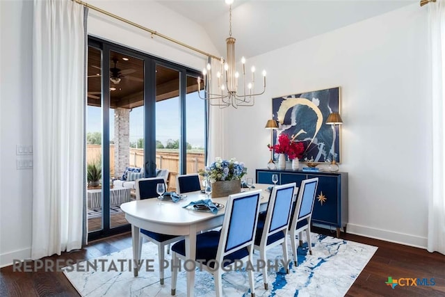 dining area featuring baseboards, lofted ceiling, an inviting chandelier, and wood finished floors