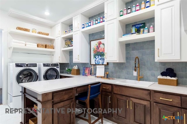 laundry room with a sink, laundry area, and separate washer and dryer