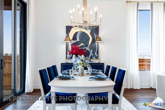 dining space featuring an inviting chandelier, wood finished floors, and baseboards