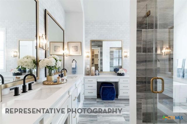 full bathroom featuring a shower stall, double vanity, and a sink