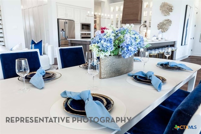 kitchen with stainless steel appliances, light countertops, glass insert cabinets, white cabinetry, and a kitchen breakfast bar