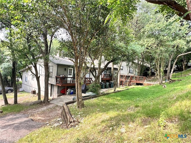 899/901 Hillyer St, San Marcos, TX 78666 - view of green lawn featuring a wooden deck, central air condition unit, and driveway