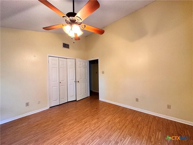 899/901 Hillyer St, San Marcos, TX 78666 - unfurnished bedroom with baseboards, wood finished floors, vaulted ceiling, a ceiling fan, and a closet