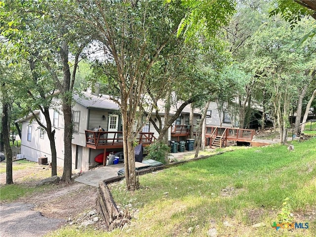 899/901 Hillyer St, San Marcos, TX 78666 - view of green lawn featuring a deck, central AC unit, and driveway