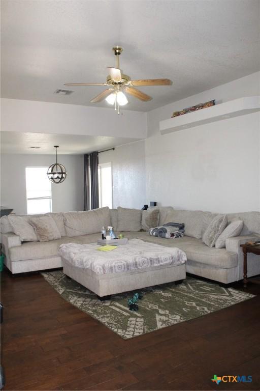 living room featuring visible vents, wood finished floors, and ceiling fan