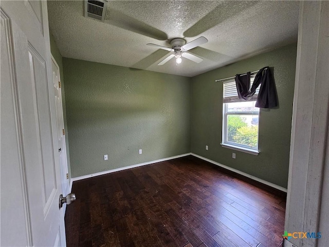 unfurnished bedroom featuring dark wood-style floors, ceiling fan, visible vents, baseboards, and a textured ceiling