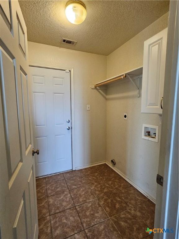 laundry room with hookup for an electric dryer, a textured ceiling, washer hookup, visible vents, and baseboards