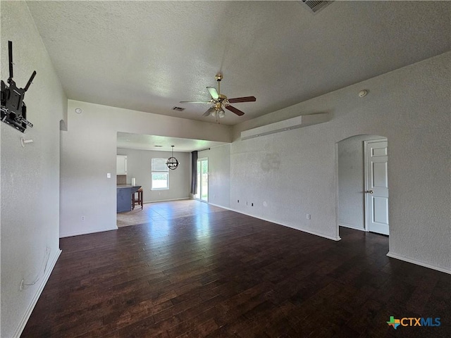 unfurnished living room featuring wood finished floors, ceiling fan, visible vents, and baseboards