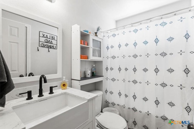 bathroom featuring vanity, a shower with shower curtain, and toilet