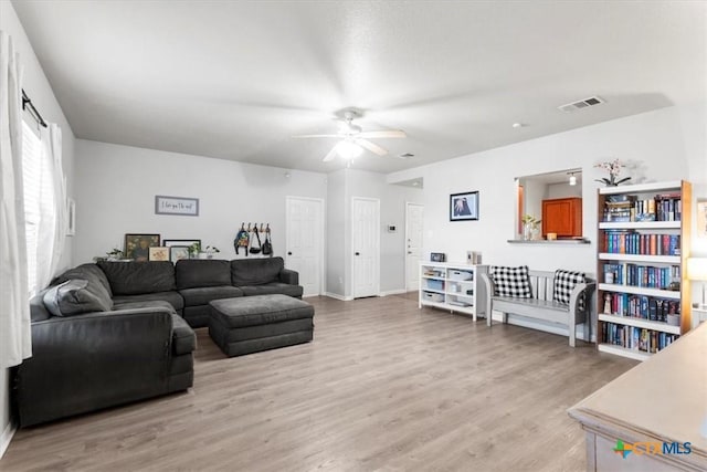 living room featuring ceiling fan and light hardwood / wood-style floors