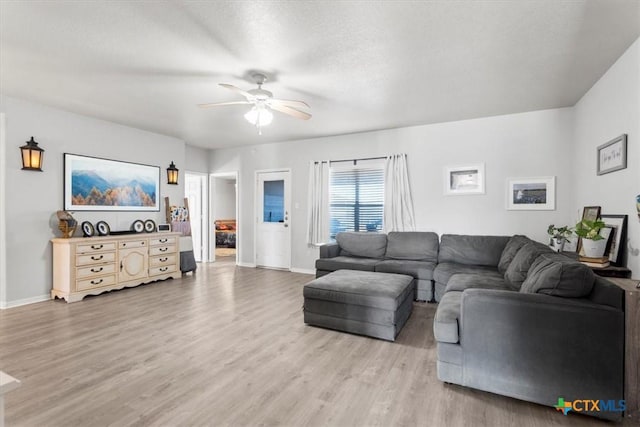 living room featuring ceiling fan, wood-type flooring, and a textured ceiling