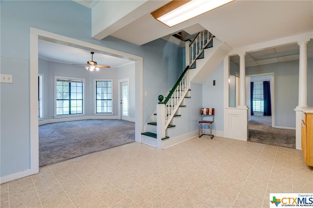 foyer with ornate columns, ornamental molding, light carpet, and ceiling fan