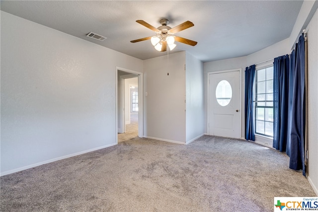 entrance foyer featuring ceiling fan and light colored carpet