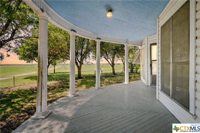 deck at dusk featuring a yard