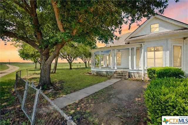 view of front of property featuring a porch and a lawn