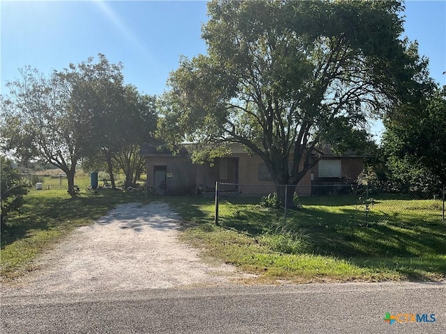 single story home featuring dirt driveway and fence private yard