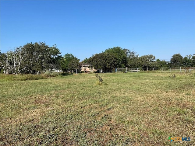 view of yard with fence and a rural view