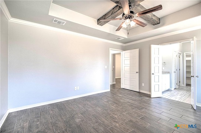 unfurnished bedroom featuring baseboards, visible vents, a raised ceiling, wood finished floors, and crown molding