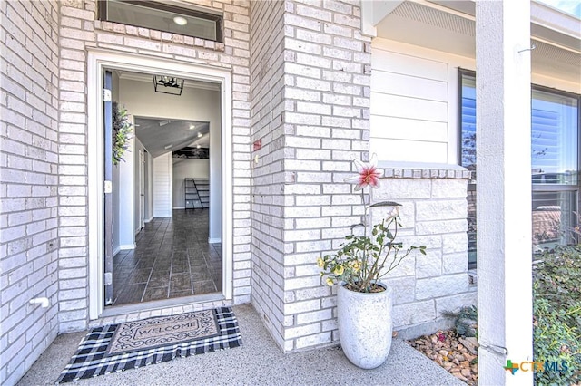 doorway to property with brick siding