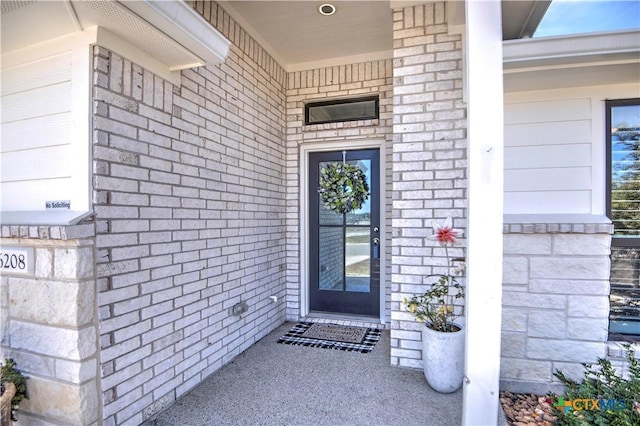 view of exterior entry with brick siding