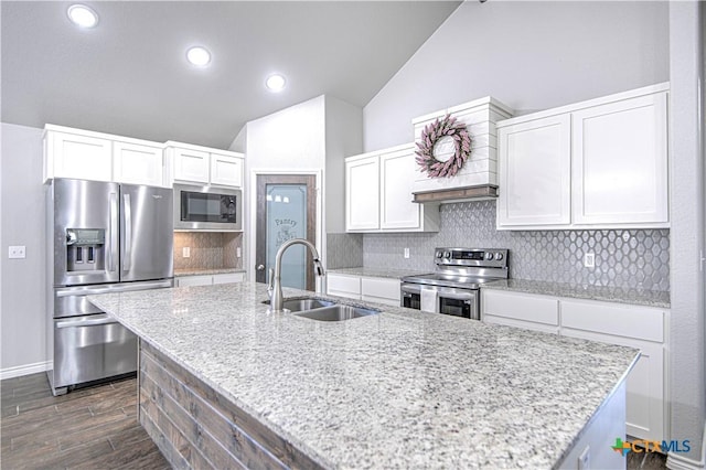 kitchen with decorative backsplash, lofted ceiling, dark wood-style floors, stainless steel appliances, and a sink