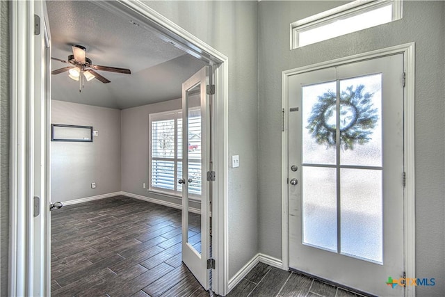 entryway featuring baseboards, a ceiling fan, and wood finish floors