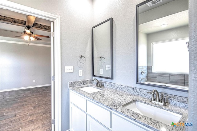 bathroom featuring visible vents, a sink, baseboards, and wood finished floors